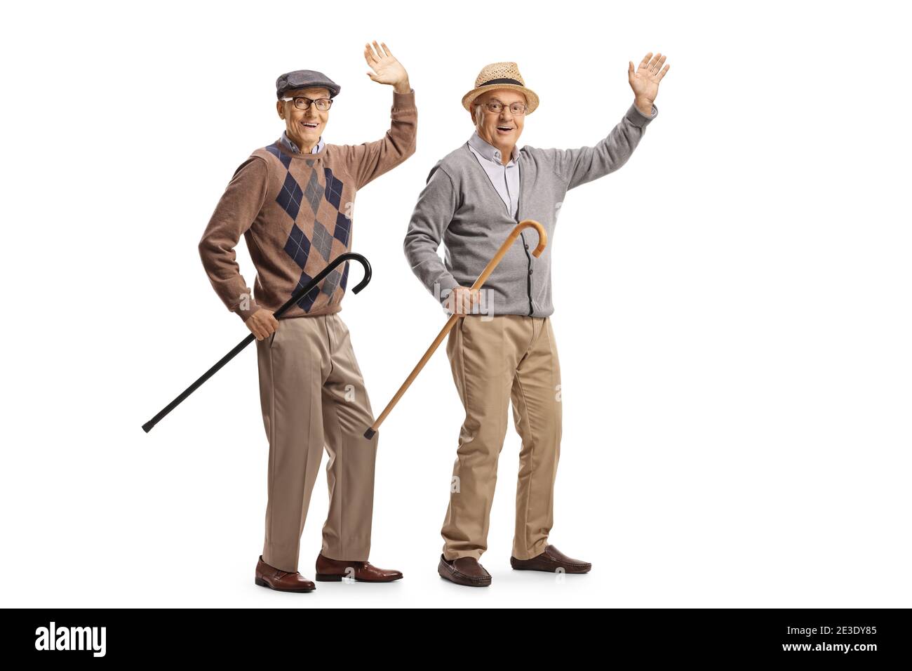 Cheerful elderly men with walking canes waving at the camera isolated on white background Stock Photo
