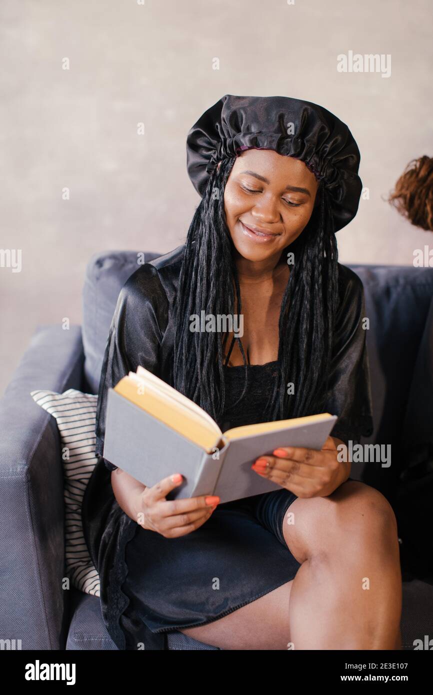 Three African American girl sitting on the couch reading a book Stock ...