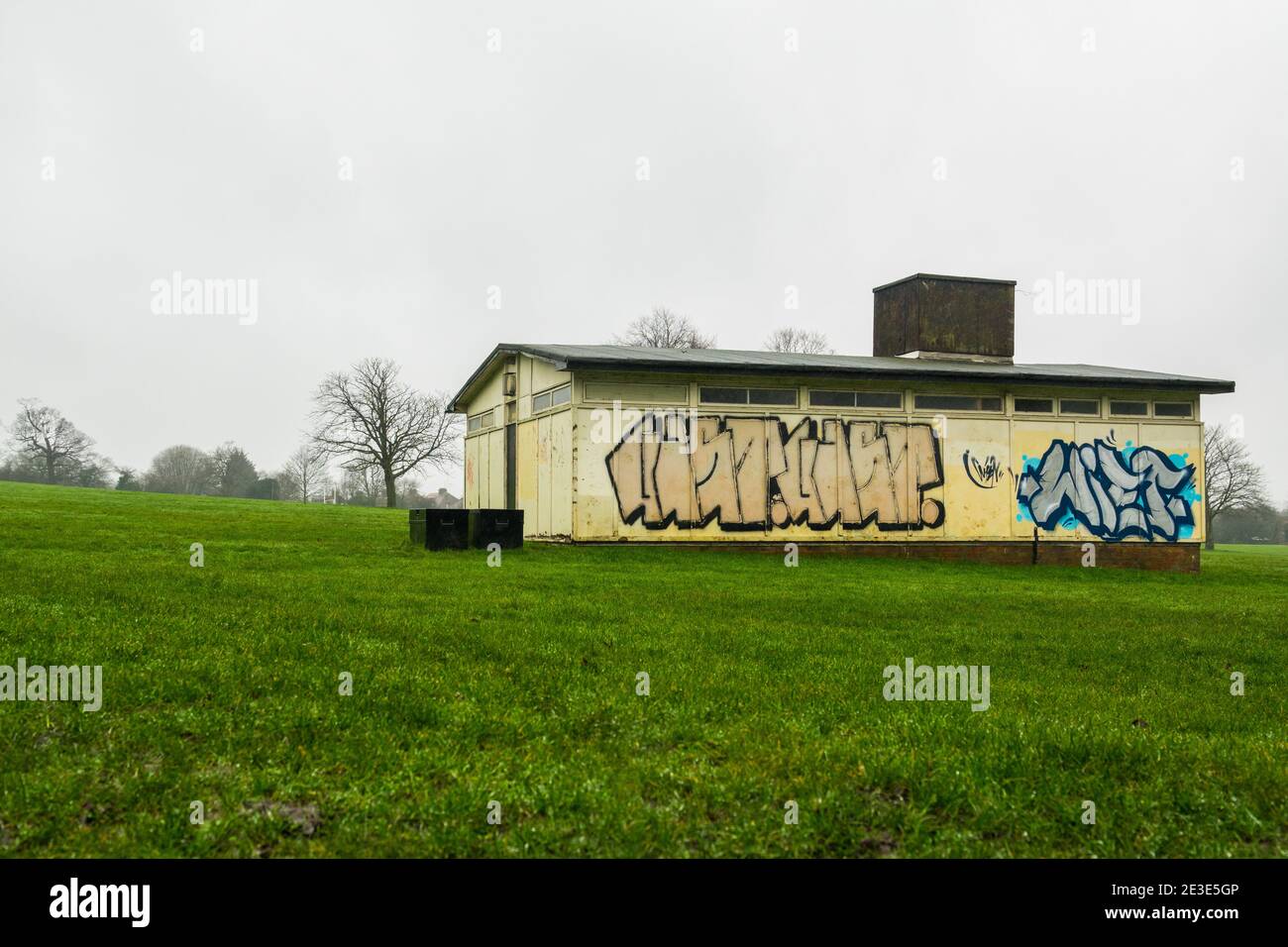 Local football and rugby clubhouse on playing fields with graffiti and ...