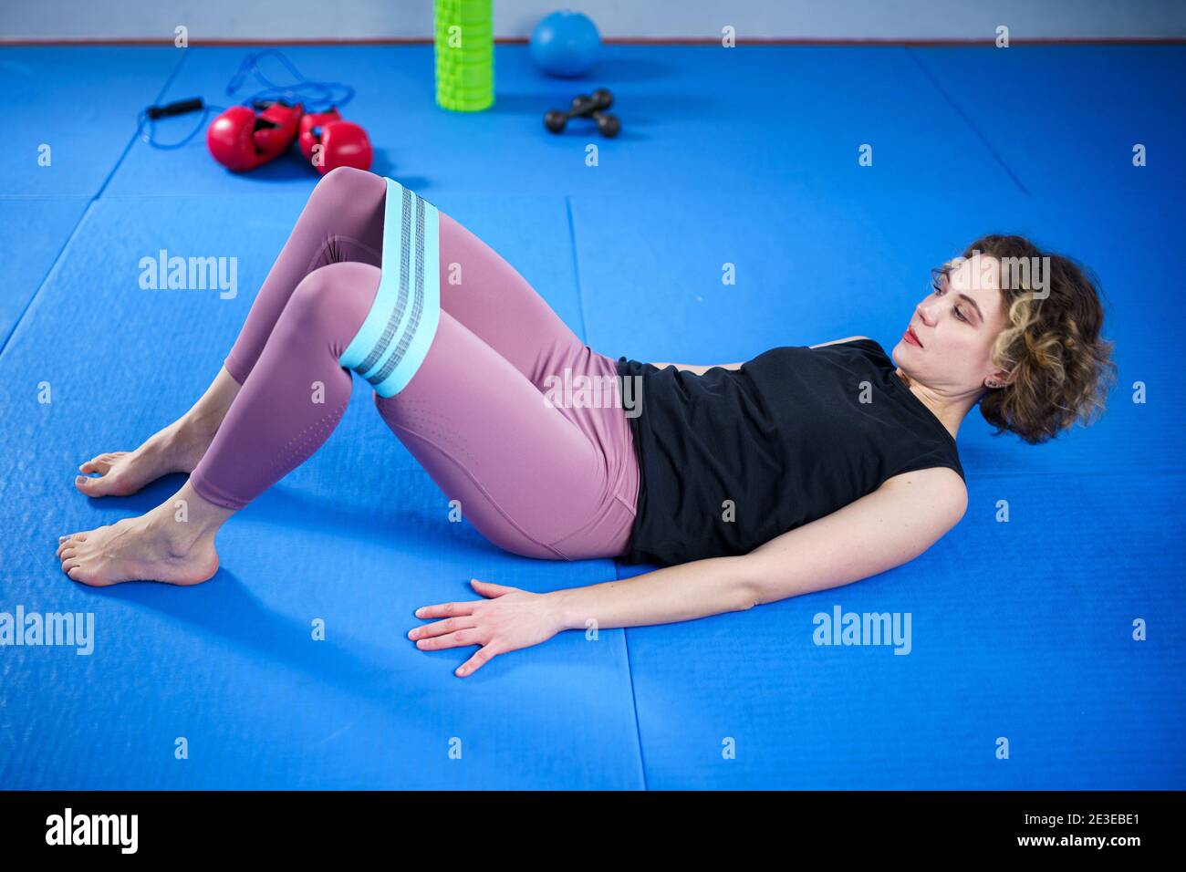 Legs woman barefoot doing pilates exercise with elastic fabric