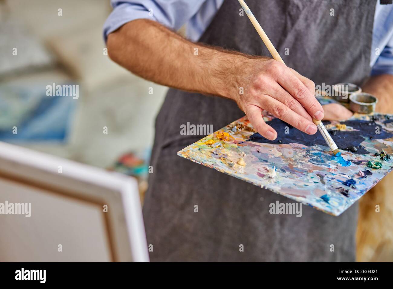 artist mix colors on palette holding in hand close up. creativity, art concept Stock Photo