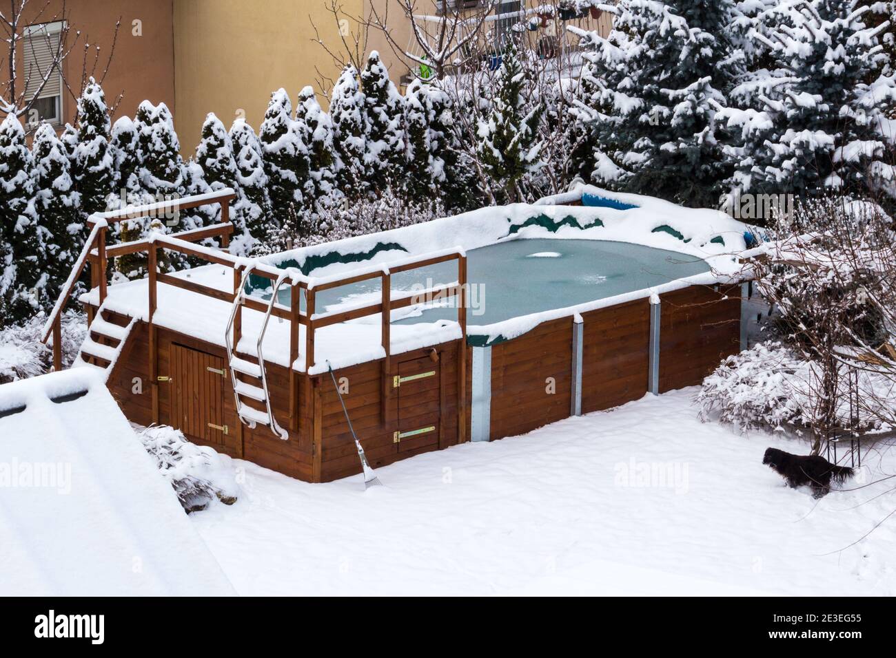 Wooden structure outdoor garden swimming pool covered with snow and ice in winter Stock Photo