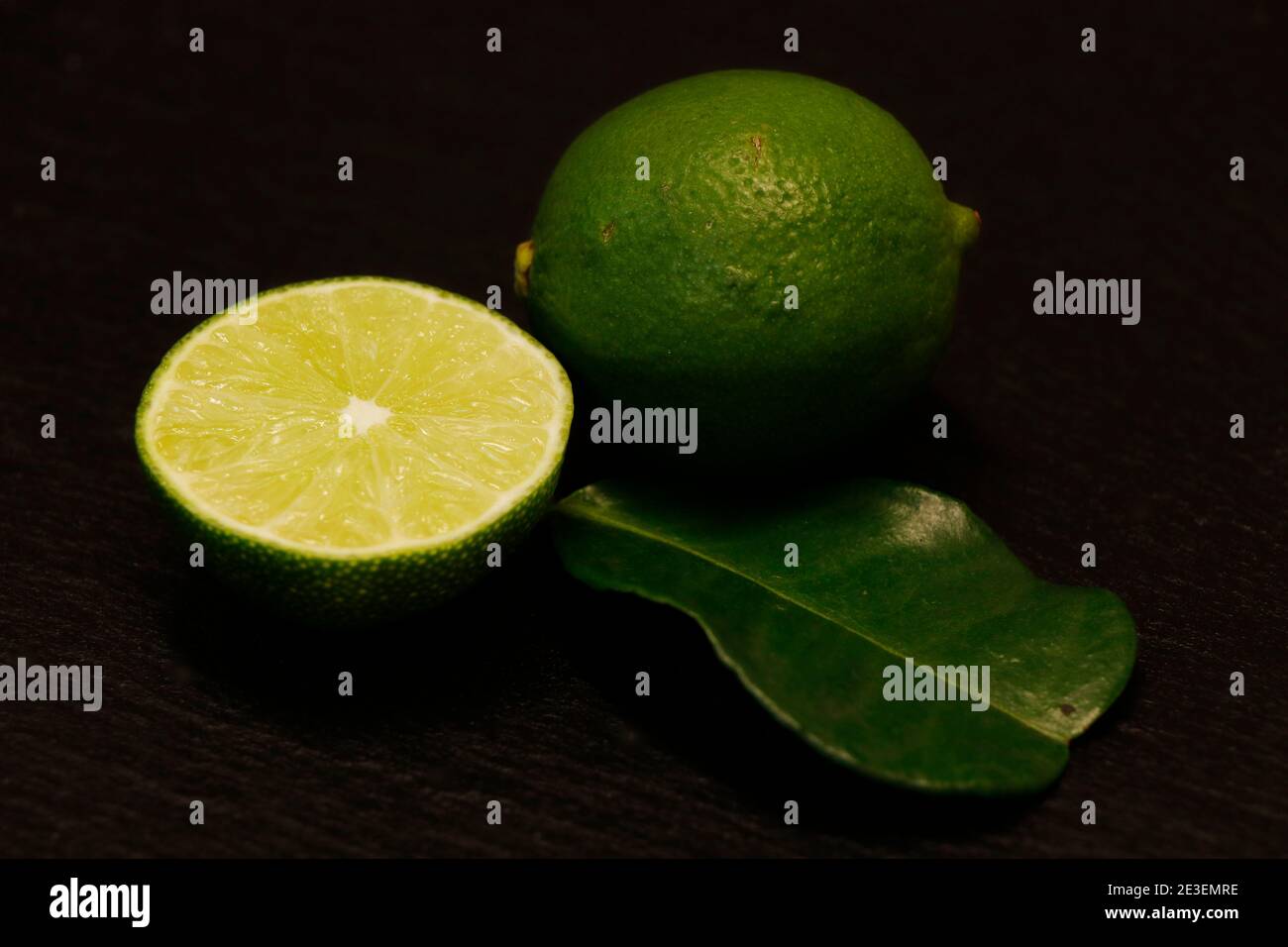 green lime and leaf isolated on a black background Stock Photo