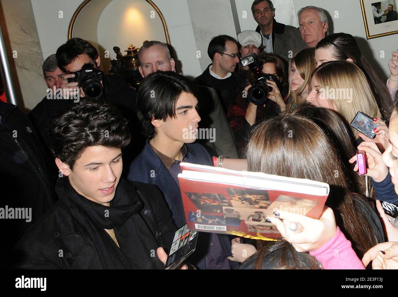 Nick and Joe Jonas sign autographs for fans during the unveiling of the ...