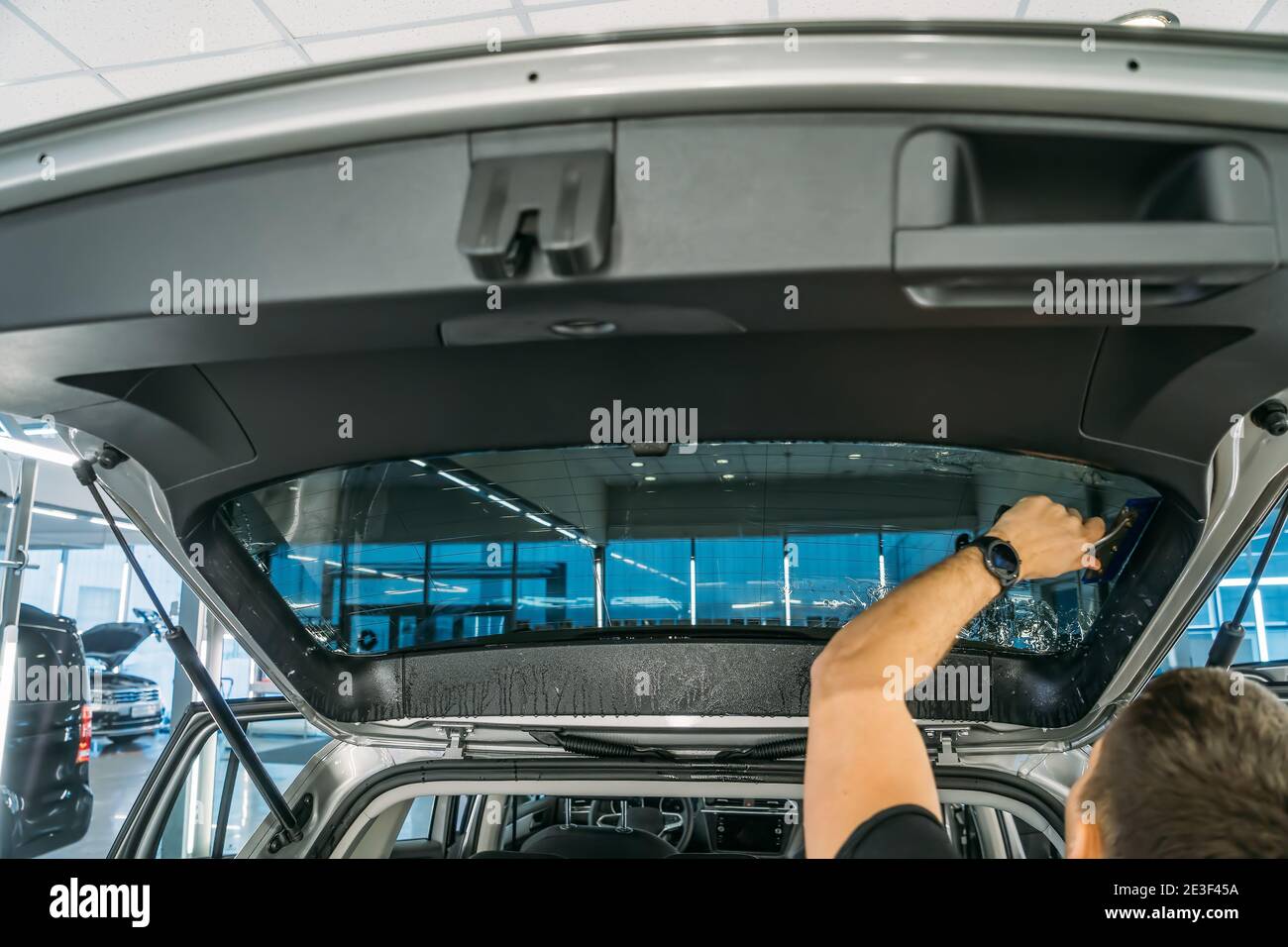 Male hand with spray, car window tint installation process, installing  procedure, tinting film Stock Photo - Alamy