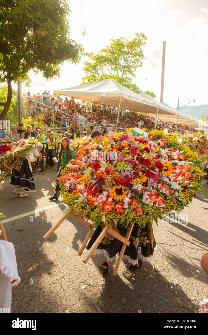 Participants carrying large floral arrangements in the Desfile de