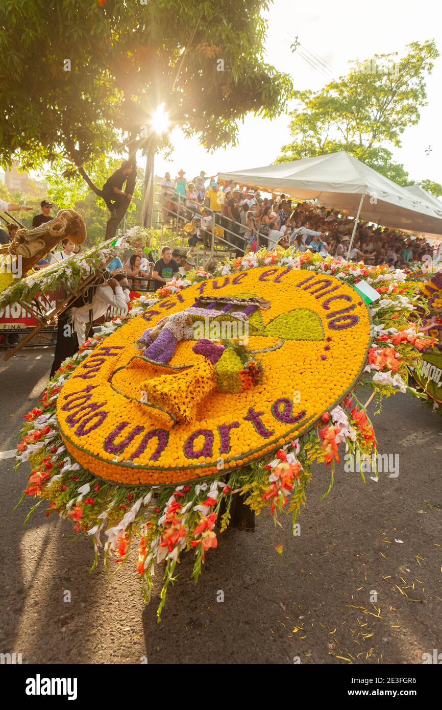 Participants carrying large floral arrangements in the Desfile de