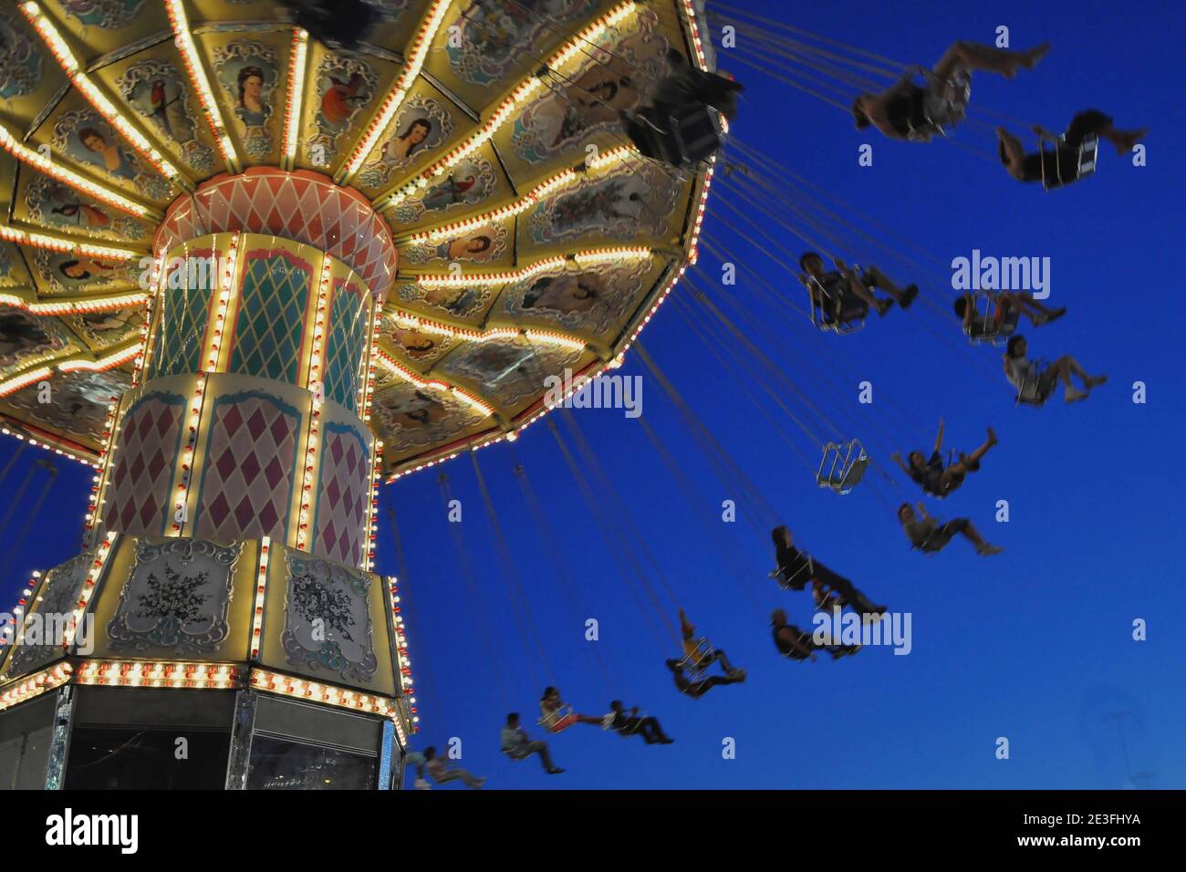 Swing ride at fair spinning around at twilight Stock Photo