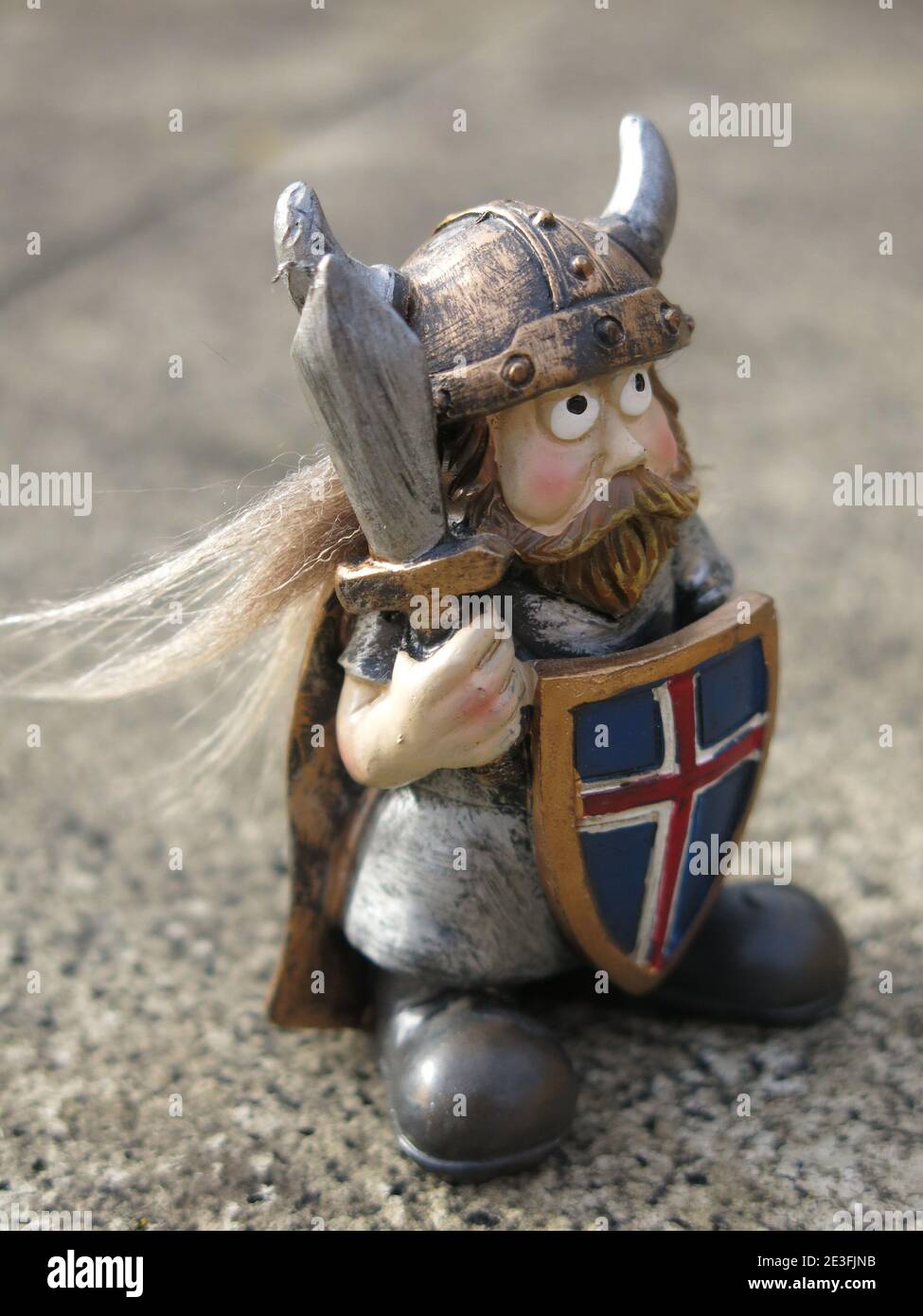A miniature Viking figure wearing a horned helmet, in battle regalia with a  dagger, and shield with the Icelandic flag Stock Photo - Alamy