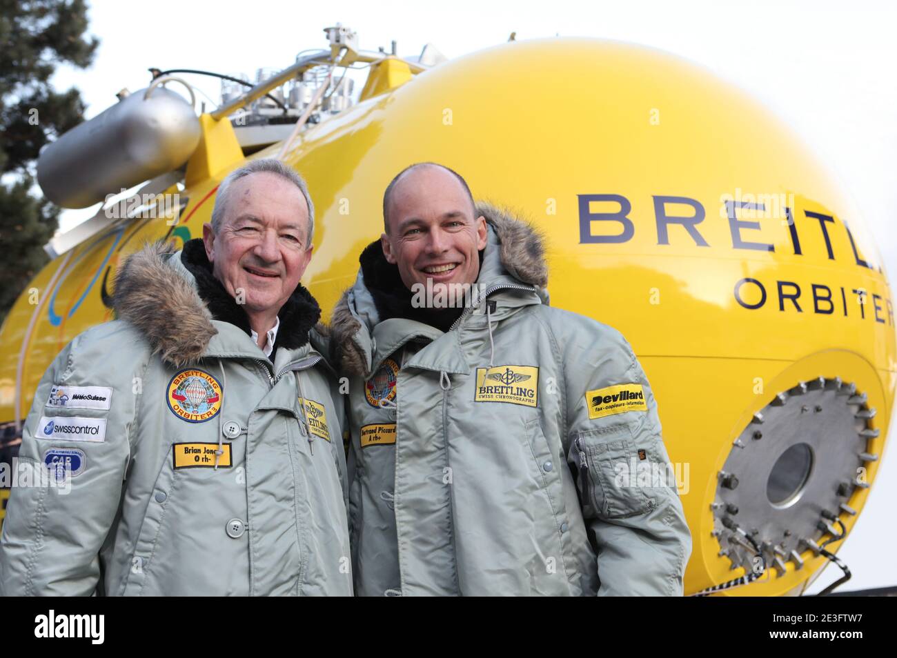 Brian Jones and Bertrand Piccard pose in Chateau-d'Oex, Switzerland on March 21, 2009. Bertrand Piccard (CH) and Brian Jones (GB) landed in the Egyptian desert on board the Breitling Orbiter 3. They had just completed the first non-stop round-the-world balloon flight, taking them 45,633 km from the Swiss village of Chateau-d'Oex in 19 days, 21 hours and 47 minutes. This flight, which broke 7 world records, remains the longest in effective distance and duration in the history of aviation. This 'Jules Verne dream', considered as the last great adventure of the 20th century, was initiated in the Stock Photo