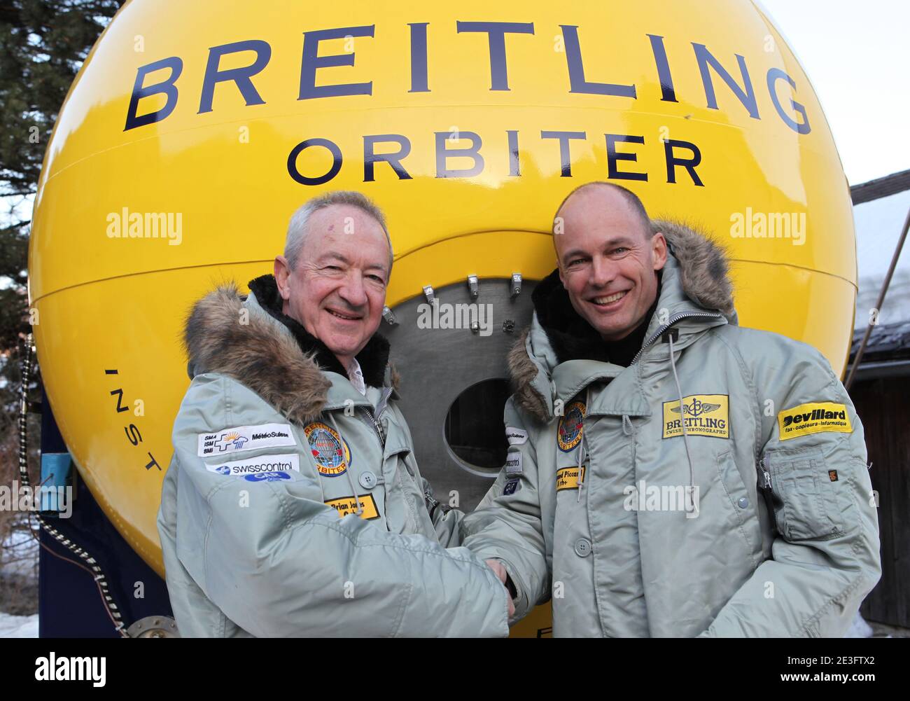 Brian Jones and Bertrand Piccard pose in Chateau-d'Oex, Switzerland on March 21, 2009. Bertrand Piccard (CH) and Brian Jones (GB) landed in the Egyptian desert on board the Breitling Orbiter 3. They had just completed the first non-stop round-the-world balloon flight, taking them 45,633 km from the Swiss village of Chateau-d'Oex in 19 days, 21 hours and 47 minutes. This flight, which broke 7 world records, remains the longest in effective distance and duration in the history of aviation. This 'Jules Verne dream', considered as the last great adventure of the 20th century, was initiated in the Stock Photo