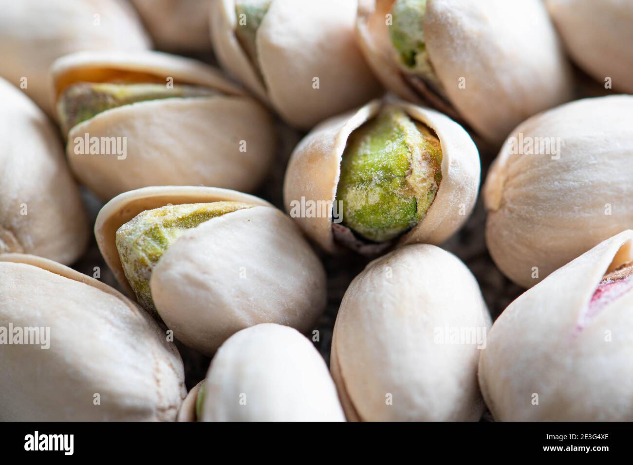 Pistachios close up macro shot featuring an open pistachio shell with the delcious green nut