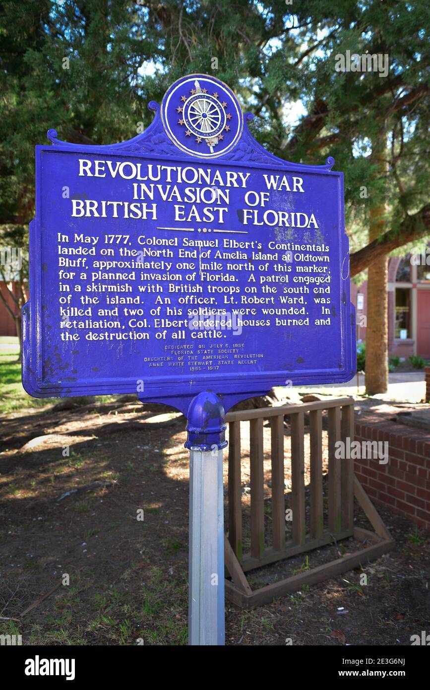 Aged, cobalt blue historical metal sign tells of the Revolutionary War Invasion of British East Florida, in Fernandina, FL on Amelia Island, sponsored Stock Photo