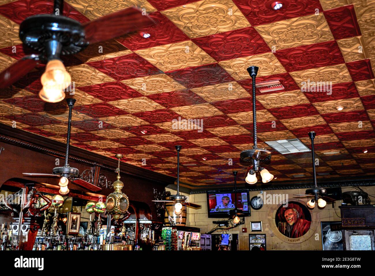 A red and yellow decorative pressed tin ceiling in the oldest bar in Florida, The Palace Saloon in Fernandian Beach on Amelia Island, FL Stock Photo