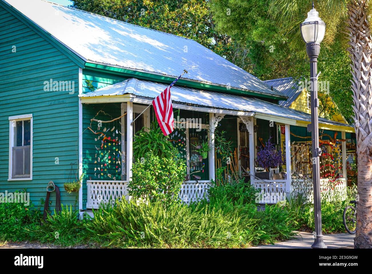 A charming old Florida style cottage with tin roof and seashell windchimes haning all around the  front porch in downtown Fernandina Beach, on Ameila Stock Photo