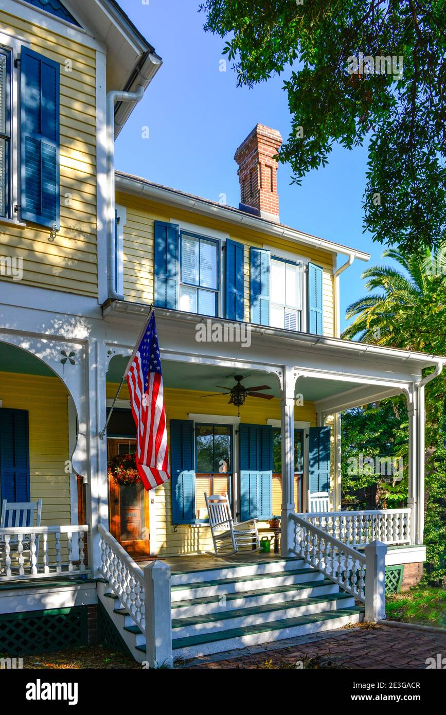 A welcoming front porch of old Victorian two storied House with rocking chairs and shutters in Fernandina Beach, FL, on historic Amelia Island Stock Photo