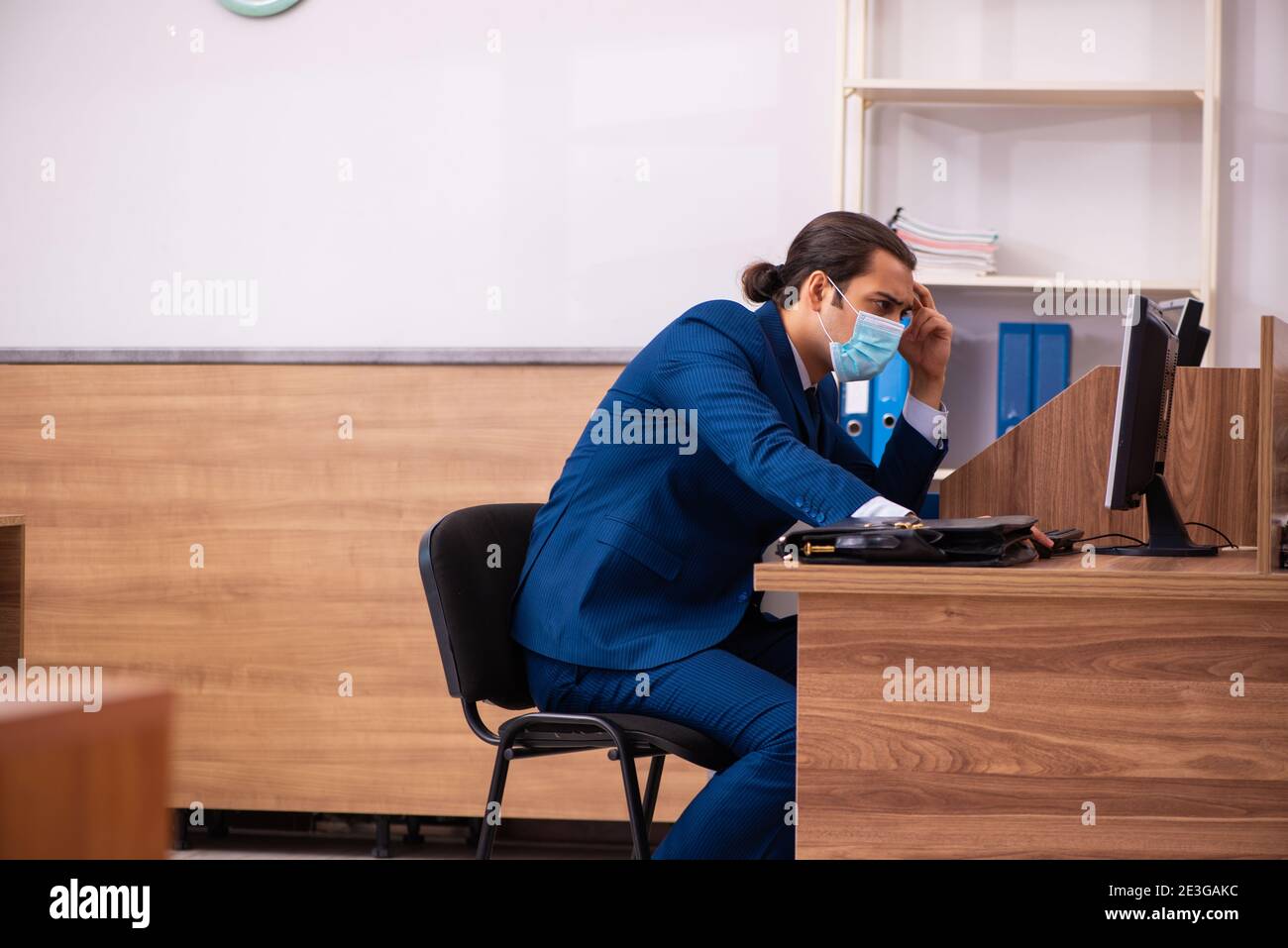 Young employee working in the office wearing mask Stock Photo - Alamy
