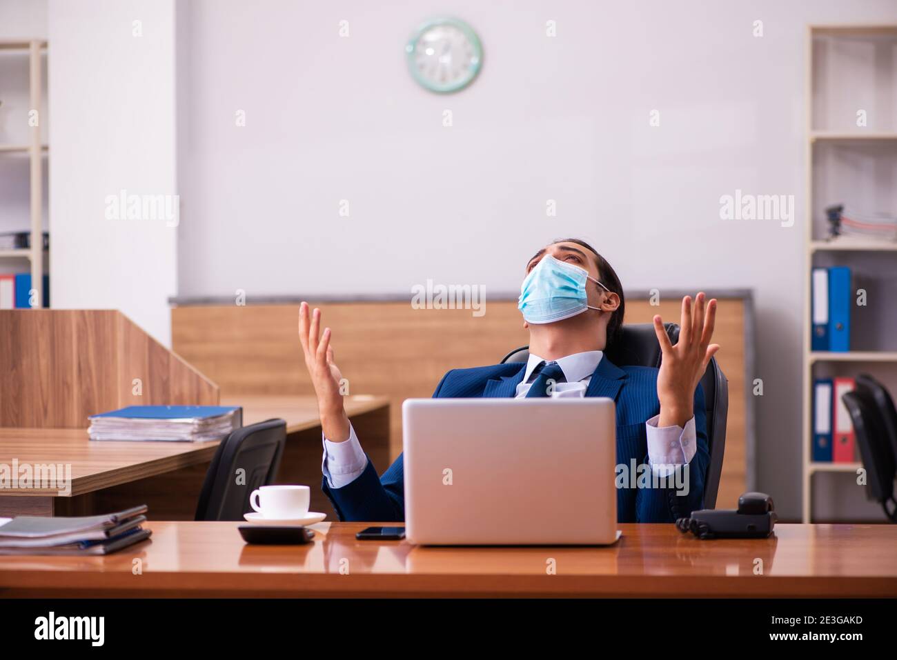 Young employee working in the office wearing mask Stock Photo - Alamy
