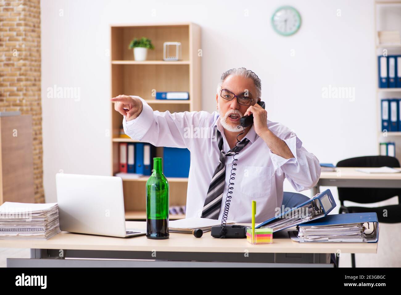 Old businessman drinking alcohol in the office Stock Photo - Alamy