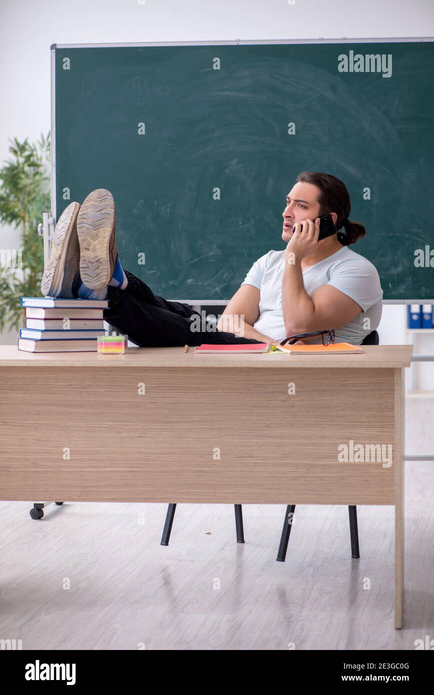 Young teacher student sitting in the classroom Stock Photo - Alamy