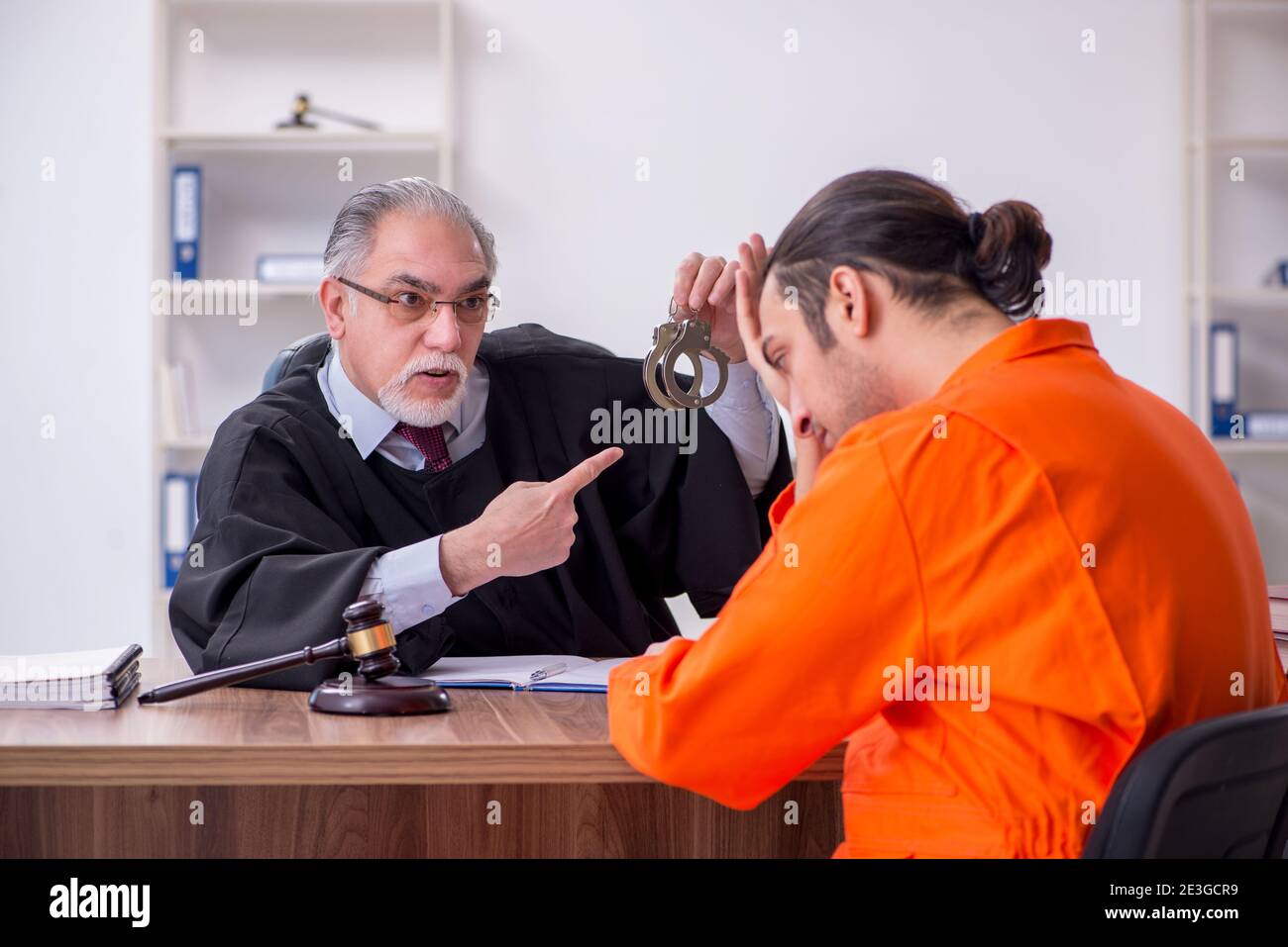 Old judge meeting with young captive in courthouse Stock Photo Alamy