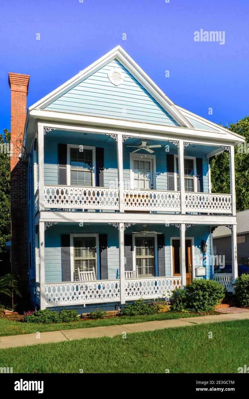 Wooden, two storied Victorian influenced home  with decortiave railings and eave accents and brick chiminey in Fernandina Beach, FL, on Amelia Island Stock Photo