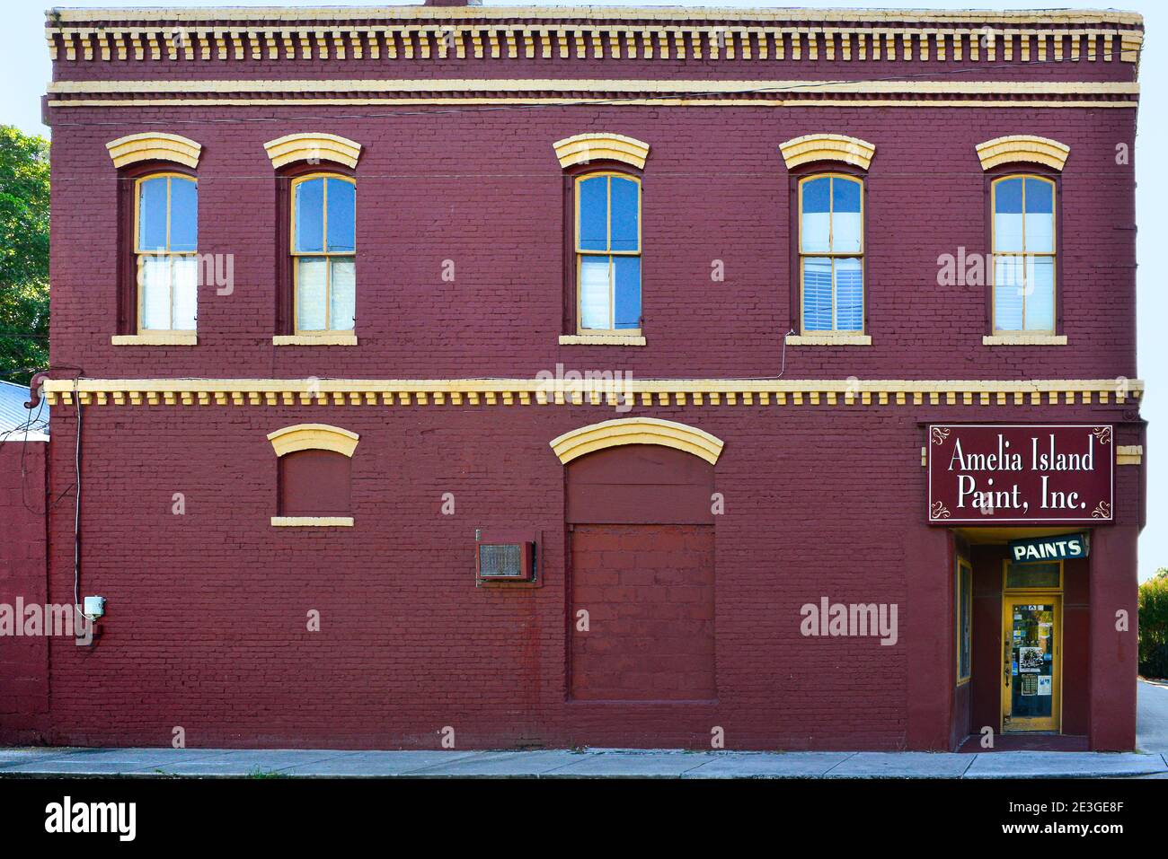 A close up of the Amelia Island Paint, Inc., a red & yellow brick commercial building erected in 1938, Fernandina Beach, on Amelia Island, FL Stock Photo