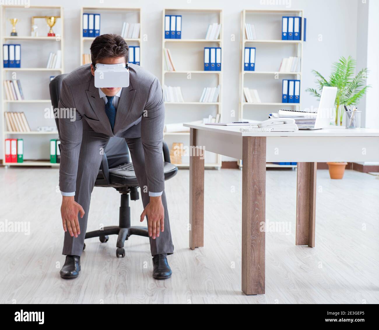 The businessman exercising in office wearing vr glasses Stock Photo - Alamy