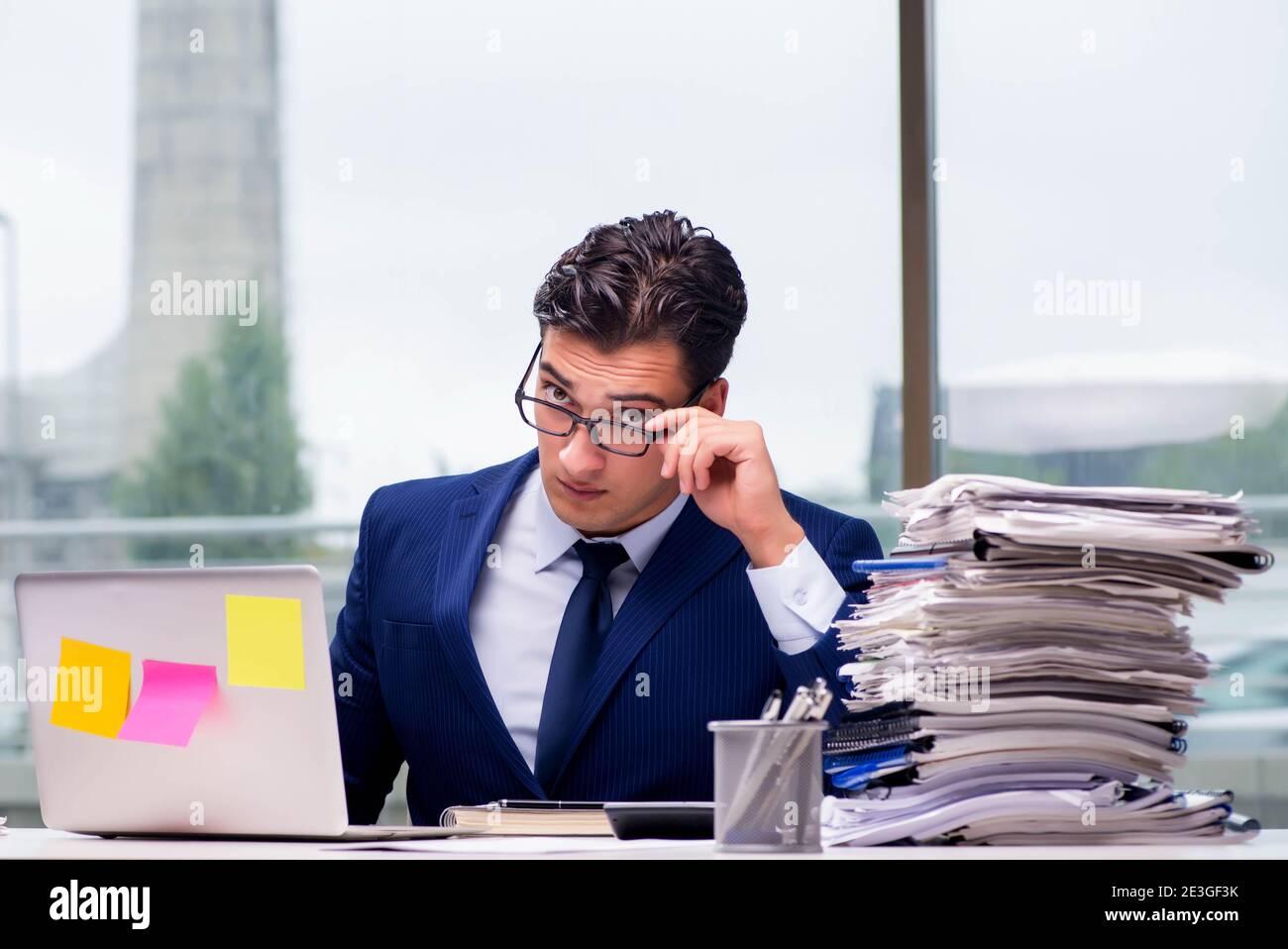 The workaholic businessman overworked with too much work in office ...