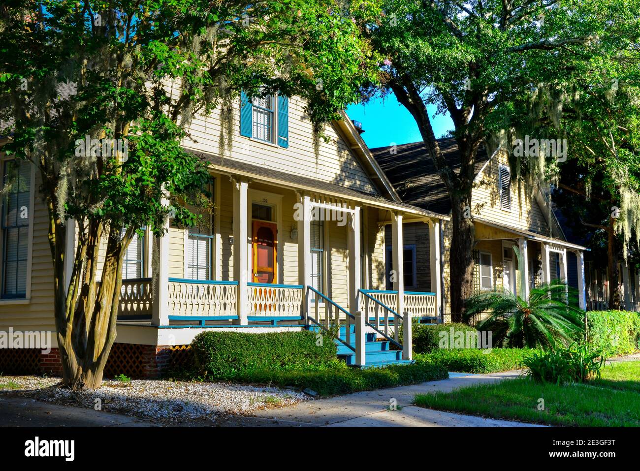 Old Florida style bungalows with front porches on Amelia Island, in historic downtown with trees hosting Spanish Moss in Fernandina Beach, FL Stock Photo