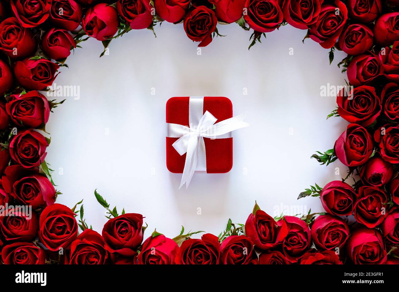 Red gift box on white background with roses frame for anniversary and ...