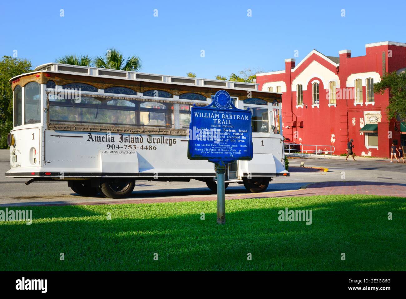 A Vintage tour bus of Amelia Island Trolleys, in historic district of Fernandina Beach, with historical sign for the Naturalist, William Bartram, FL Stock Photo