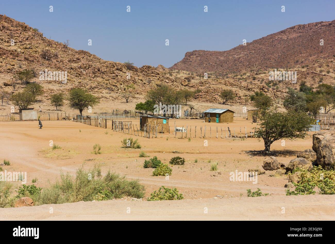 rural landscape scene in Namibia interior consisting of clay huts and a small fenced area Stock Photo