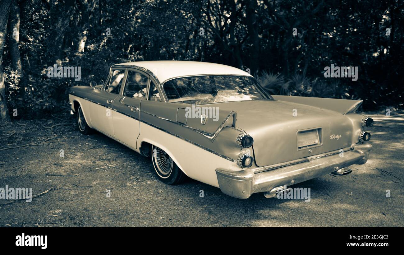 Rear side view of a vintage 1958 Dodge Custom Royal automobile, with prevalent tail fins, parked in a wooded area on Amelia Island, FL, Stock Photo