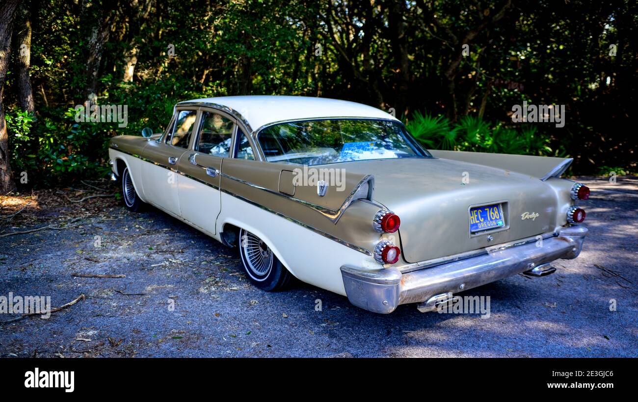 Rear side view of a vintage 1958 Dodge Custom Royal automobile, with prevalent tail fins, parked in a wooded area on Amelia Island, FL, Stock Photo