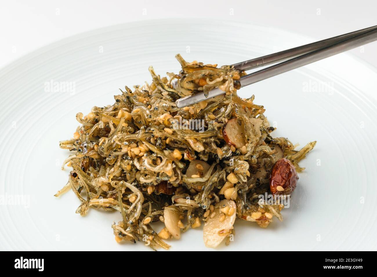 Stir-fried anchovies on white background Stock Photo - Alamy