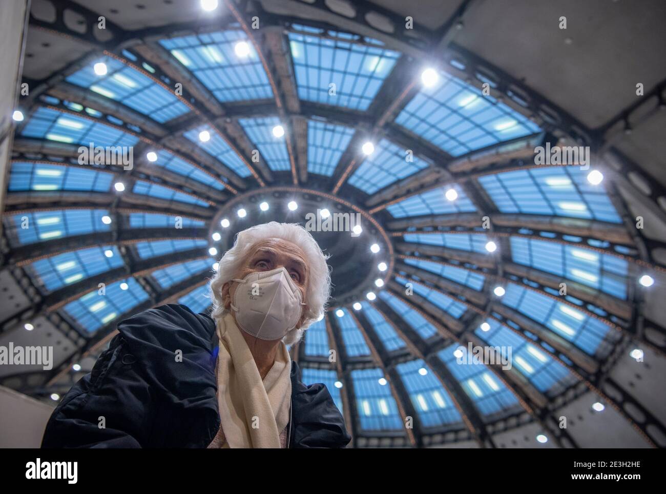 Frankfurt, Germany. 19th Jan, 2021. 19 January 2021, Hessen, Frankfurt/Main: After receiving her vaccination against the novel coronavirus, 90-year-old Odores H. sits under the domed roof of the vaccination centre in the Festhalle in Frankfurt. This is where thousands of people usually gather for concerts and trade fairs, and where the state of Hesse operates one of its vaccination centers. On the first day of regular operation, around 500 people are to be vaccinated against Corona here. Photo: Boris Roessler/dpa Pool/dpa Credit: dpa picture alliance/Alamy Live News Stock Photo