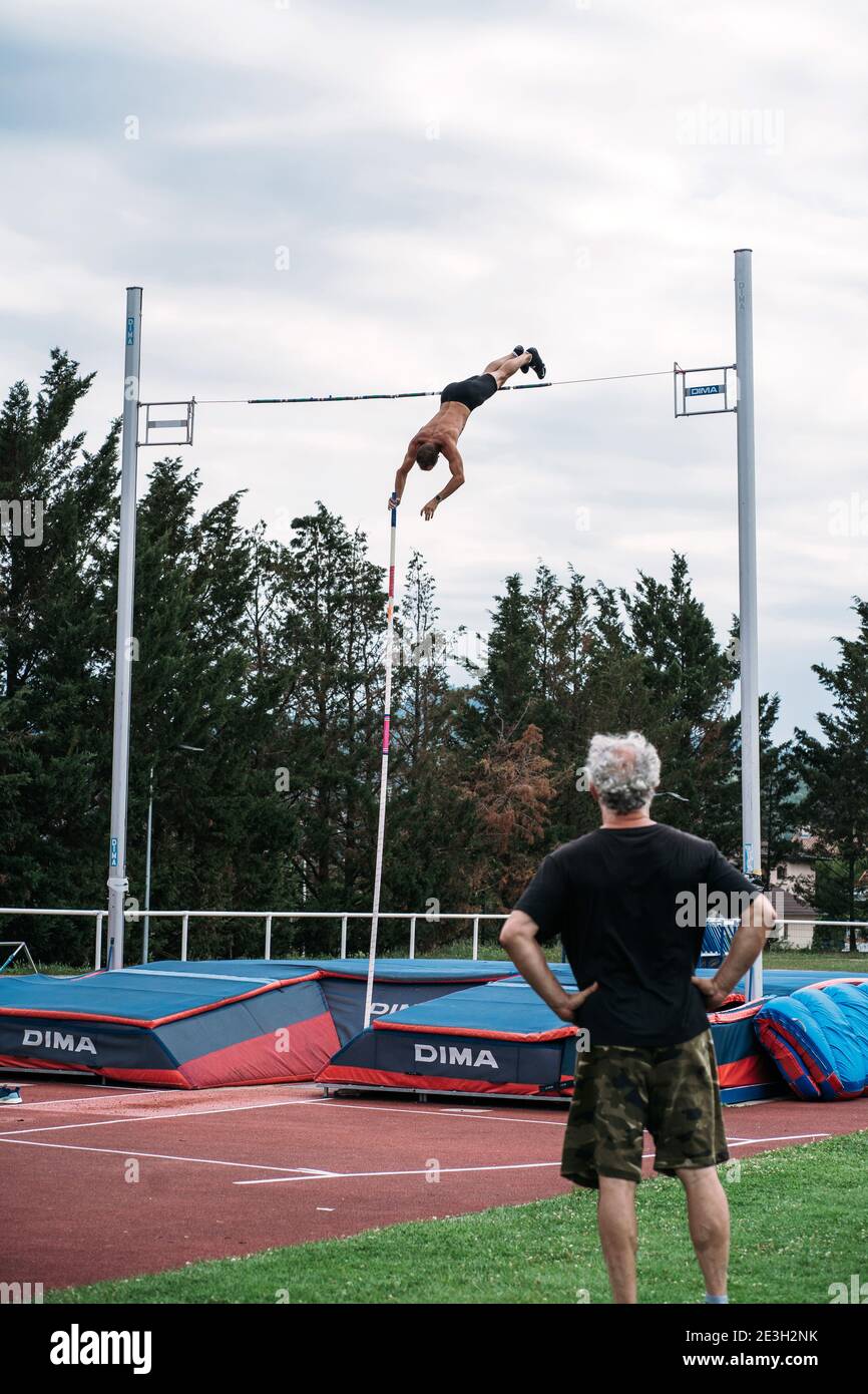 Jump over the bar in front of the coach Stock Photo Alamy