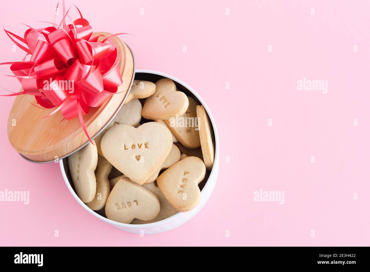 Box with heart-shaped cookies with decorations on a pink background. Copy space. Stock Photo