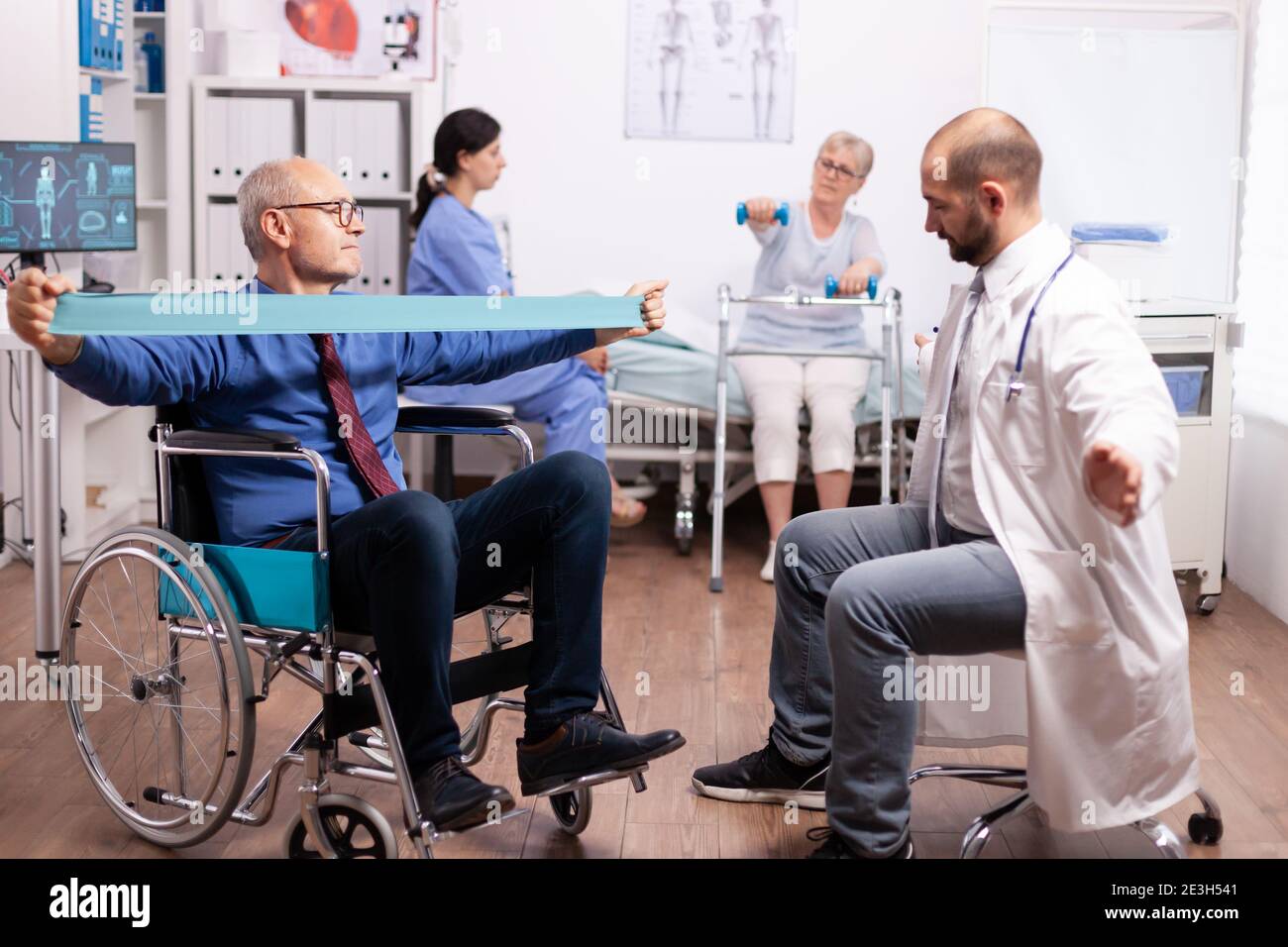 Physiotherapist working with handicapped senior man in modern clinic Elderly invalid patients in