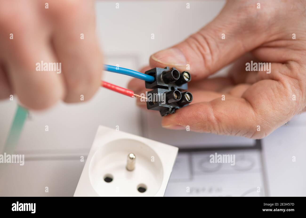 Electrician hands connecting wires in terminal block Stock Photo