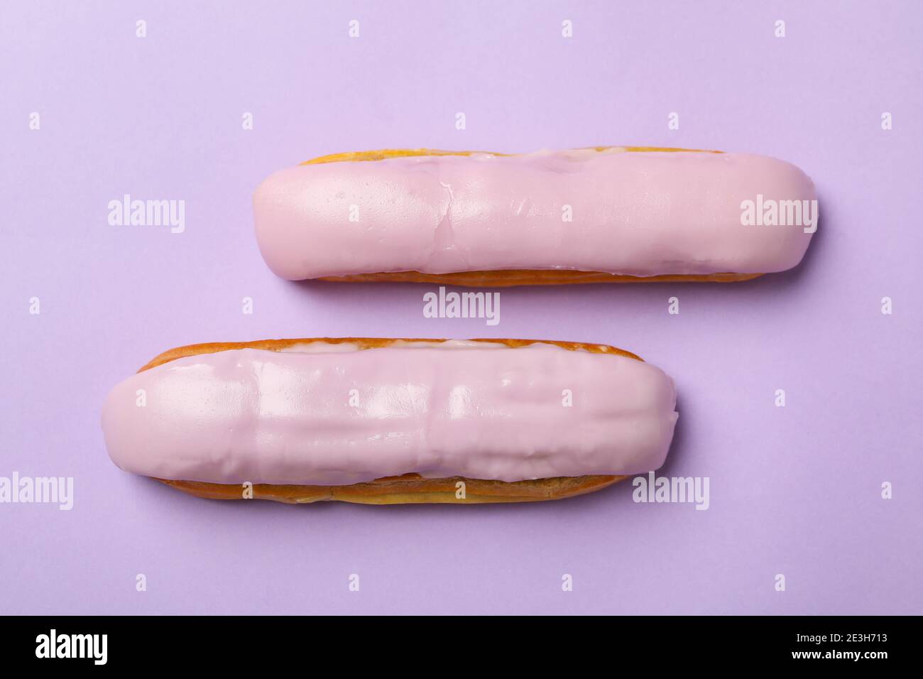 Delicious eclairs with custard on violet background Stock Photo