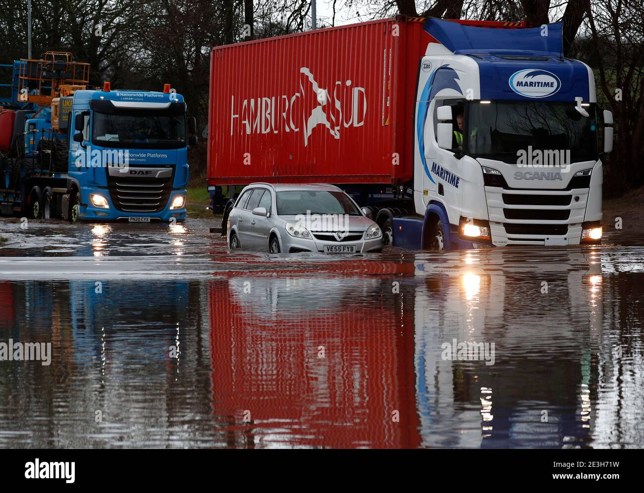 Hathern, Leicestershire, UK. 19th January 2021. UK weather. Lorries are driven past a car stranded in flood water. Storm Christoph is set to bring widespread flooding to parts of England. Credit Darren Staples/Alamy Live News. Stock Photo