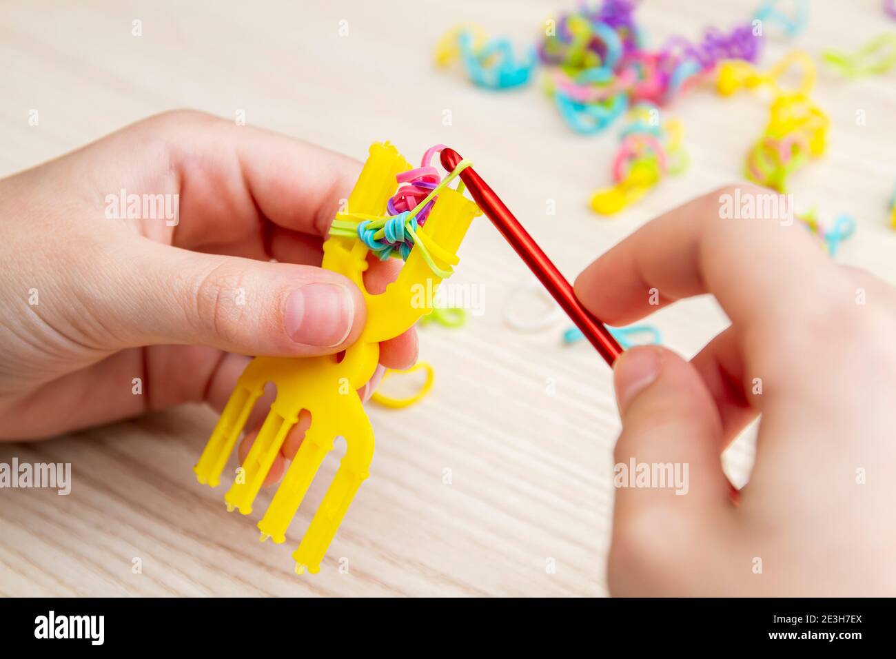 Rubber Band Weaving. Knitting rubber bands with loom knit. Hands of