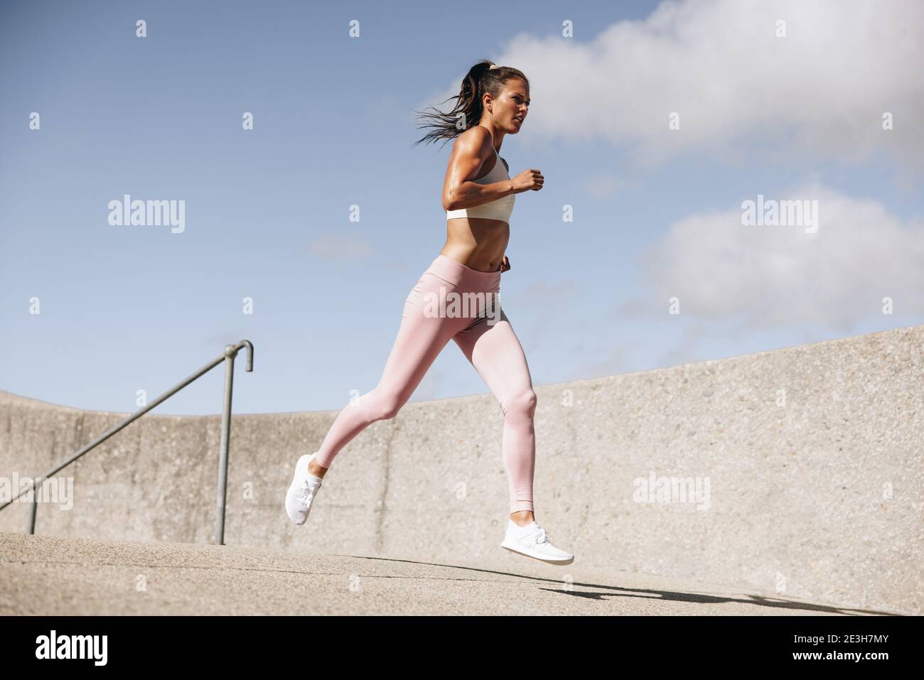 Healthy woman on morning run. Female in fitness wear on running workout. Stock Photo