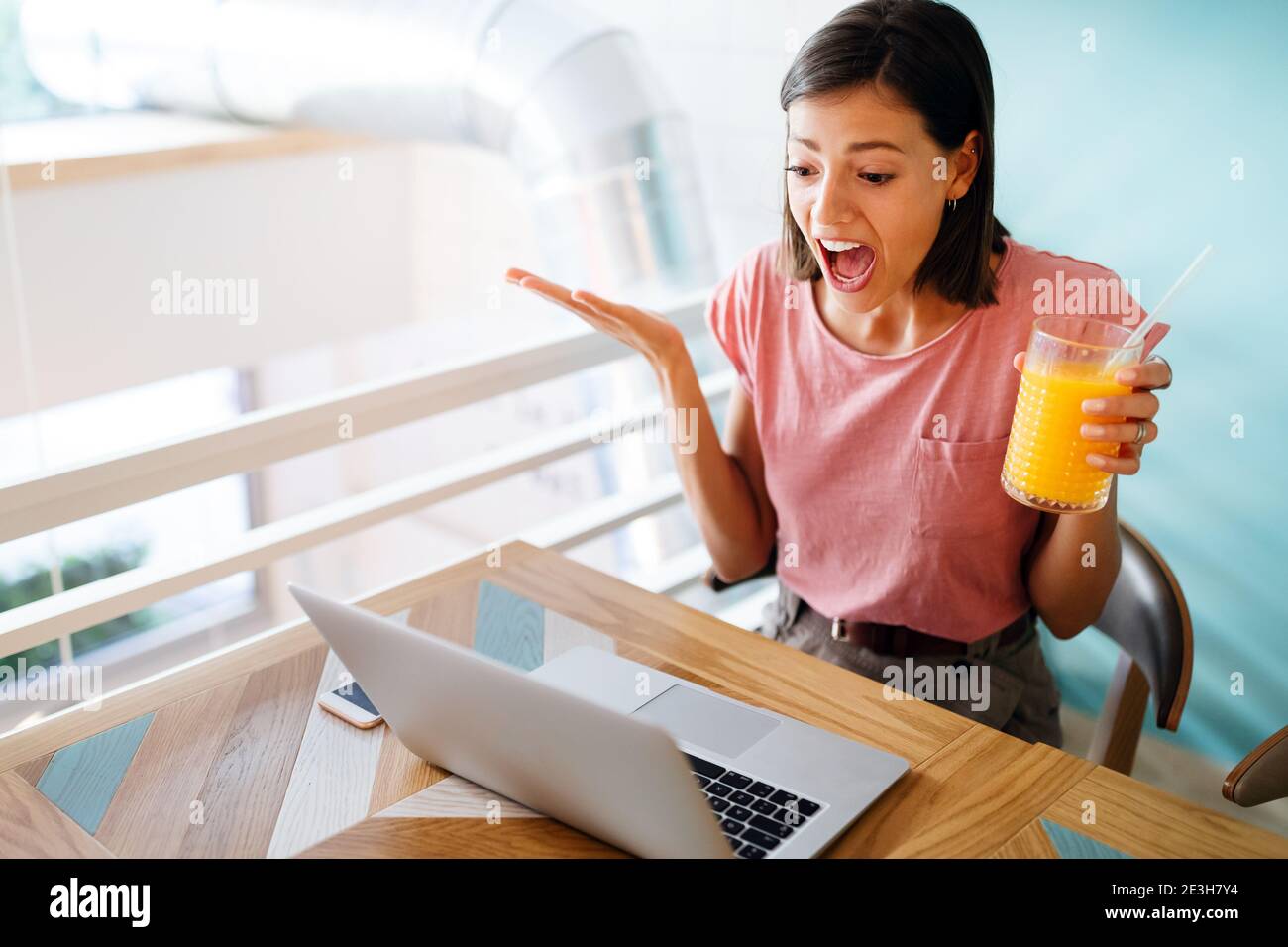 Confused shocked beautiful young woman looking at tablet computer Stock Photo