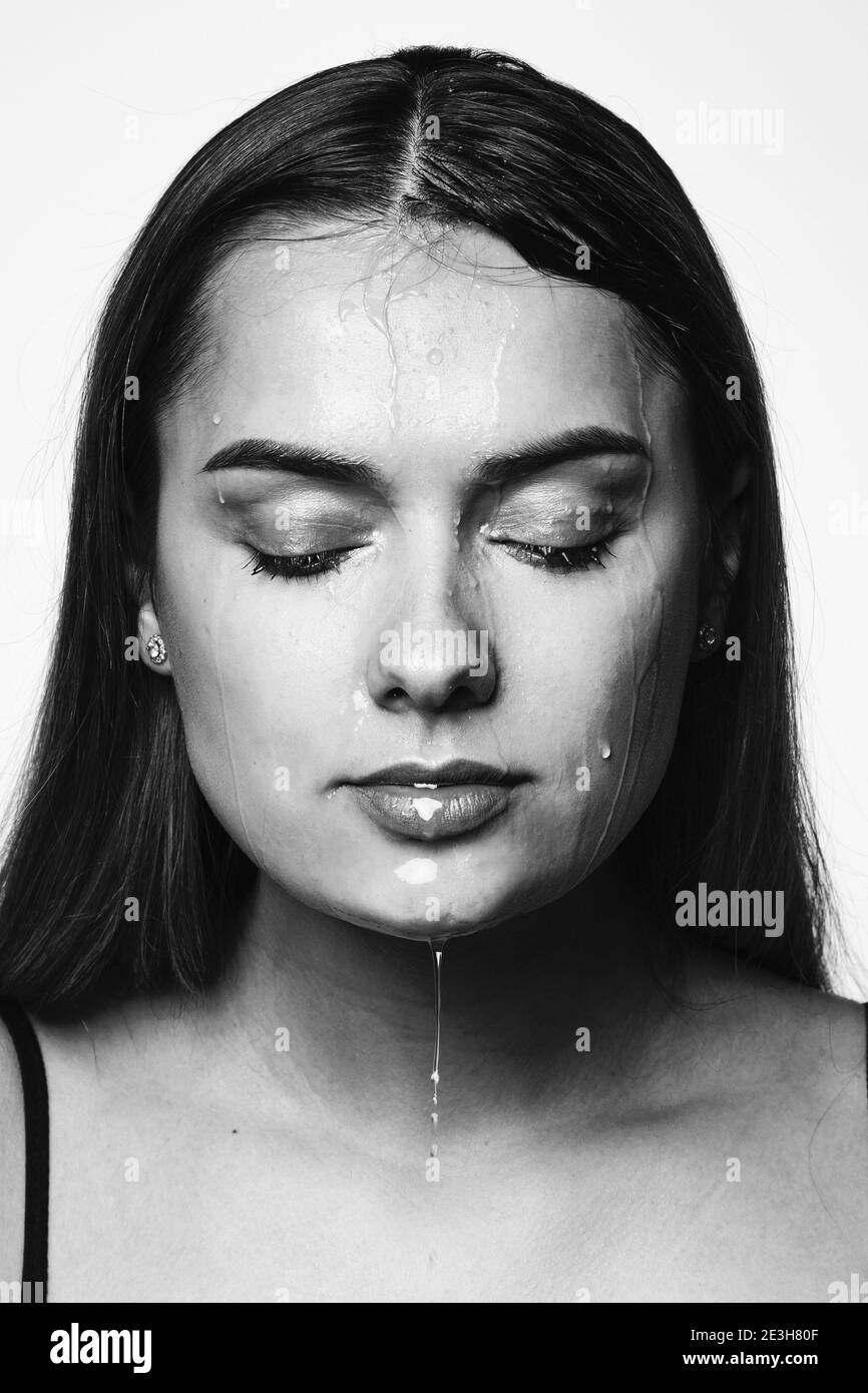 Clean skin, drops and trickles of water on the face. Young beautiful woman, close-up portrait. Stock Photo