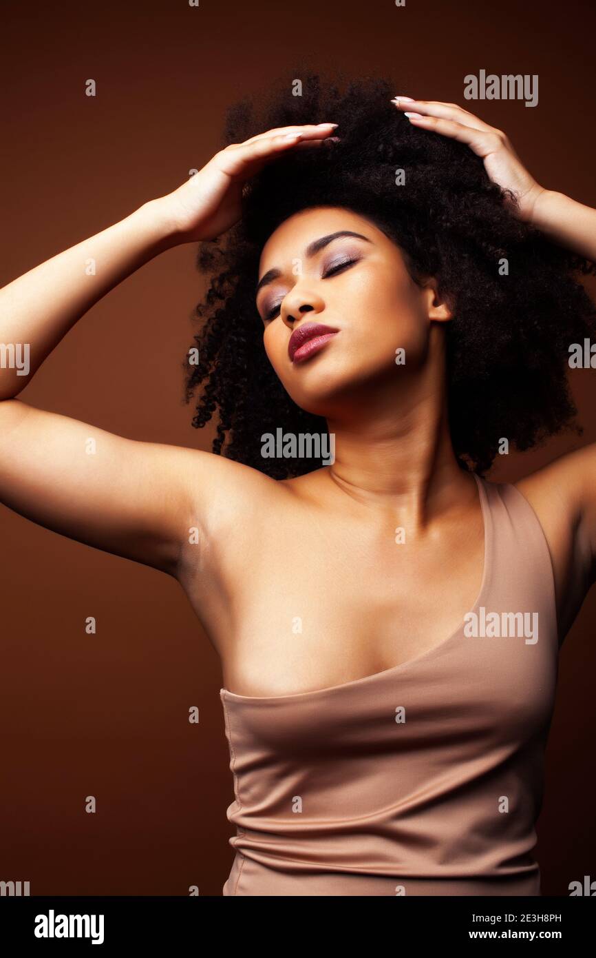 pretty young african american woman with curly hair posing cheerful ...