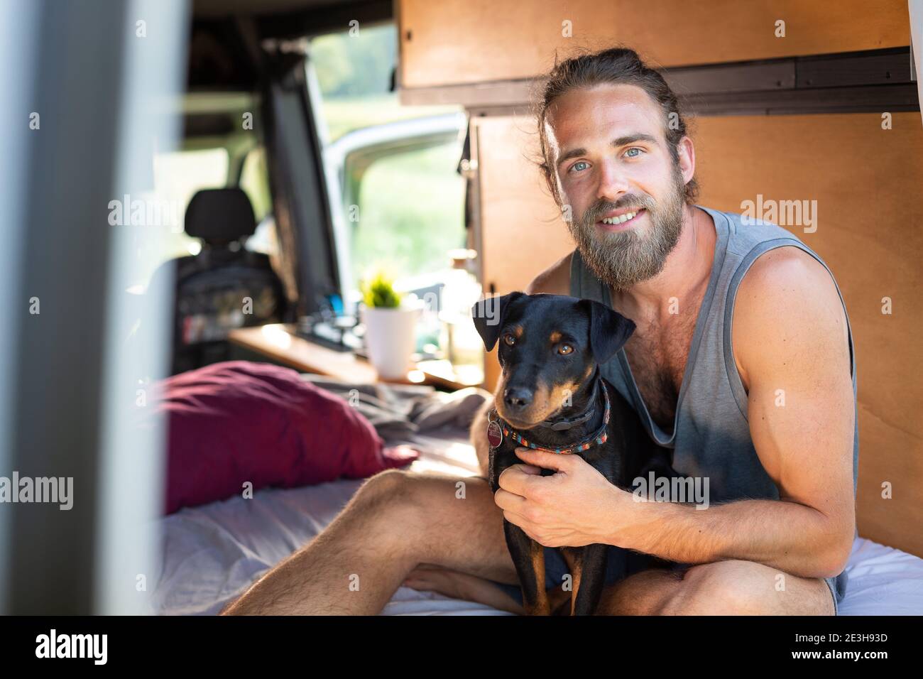 Man with his dog inside a caravan Stock Photo