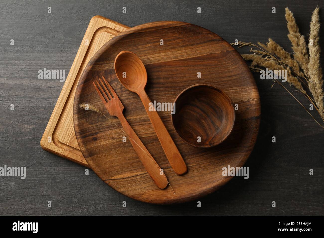 Different wooden kitchenware on dark table, top view Stock Photo - Alamy